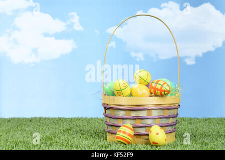 wicker basket full of colorful easter eggs Stock Photo
