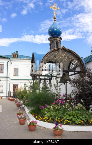 KAZAN, TATARSTAN, RUSSIA-CIRCA JUN, 2017: Pavilion and belltower is on the area of the Kazan Bogoroditsky Monastery. Bronze bells hand under blue roof Stock Photo