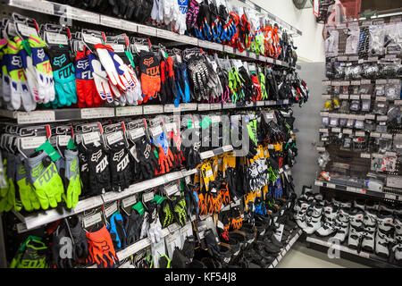 HELSINKI, FINLAND - CIRCA DEC, 2016: A lot of motorcycle leather gloves hanging in  motorbike store. The Motonet is a large chain retailer of auto and Stock Photo