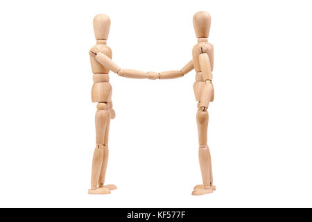 Two wooden dummies shaking hands over white background Stock Photo