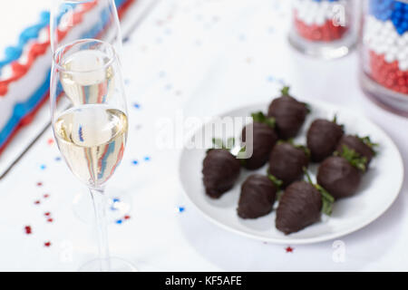 Glasses of champagne against cake and chocolate strawberries on table at election rally Stock Photo