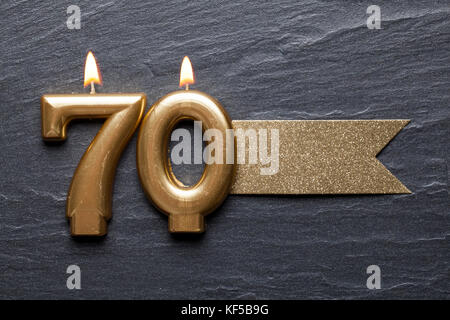 Gold number 70 celebration candle with glitter label Stock Photo