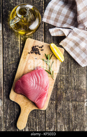 Fresh raw tuna steak on cutting board.