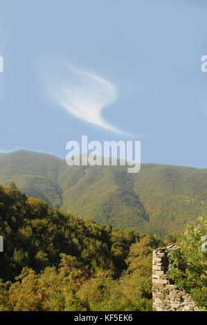 Cirrus Uncinus cloud formation, over the abandoned, Appennine. village of Vecchio Connio, Carrega Ligure, in the region of Piedmont, Northern Italy.