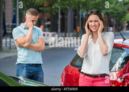 Worried Man Standing Behind Woman Suffering From Head Pain Stock Photo