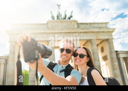 Close-up Of Young Happy Couple Taking Selfie In Front Of Brandenburg Gate In Germany Stock Photo