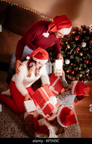 Top view of happy family giving presents each other for Christmas at home. Stock Photo