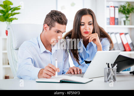 Young business people working on tablet in the office. Stock Photo