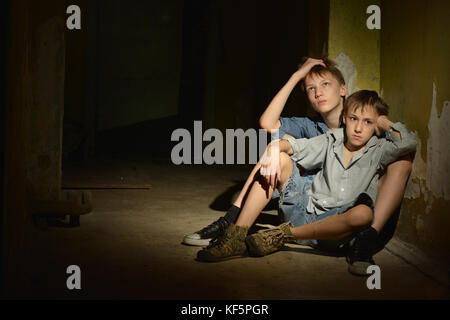 Two little boys in dark cellar Stock Photo