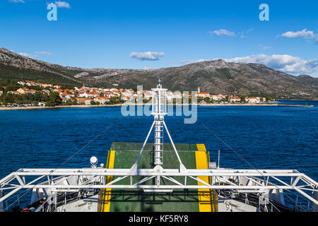 The charming town of Orebic on the Peljesac Peninsula (in Croatia) begins to fill the frame behind the front of a car ferry as it returns from Korcula Stock Photo