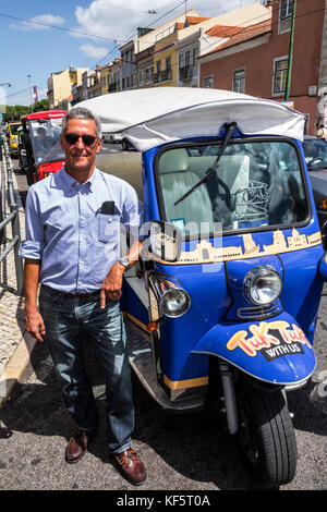 Lisbon Portugal,Belem,historic district,Rua de Belem,tuk-tuk,tricycle,cycle rickshaw,Hispanic,immigrant immigrants,man men male,driver,hire,Hispanic,i Stock Photo