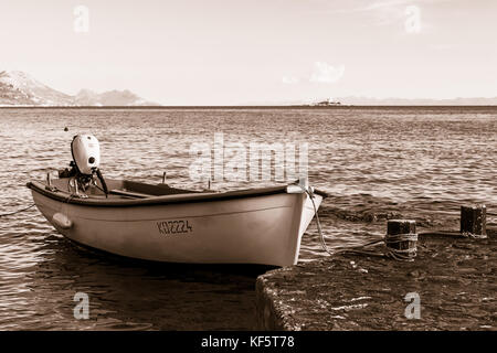 A sepia/split toned image of a small fishing boat moored to the waters edge in Orebic, the charming seaside town on the Peljesac peninsula in Croatia. Stock Photo