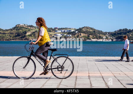 Lisbon Portugal,Belem,Tagus River,waterfront,promenade,woman female women,bicycle bicycles bicycling riding biking rider riders bike bikes,riding,view Stock Photo
