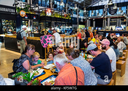 Lisbon Portugal,Cais do Sodre,Mercado Da Ribeira,Time Out Market,market hall,food court plaza,dining,tables,crowded,busy,man men male,woman female wom Stock Photo