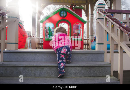 Toddler walking toward Christmas or holiday displays. Stock Photo