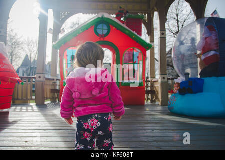 Toddler walking toward Christmas or holiday displays. Stock Photo