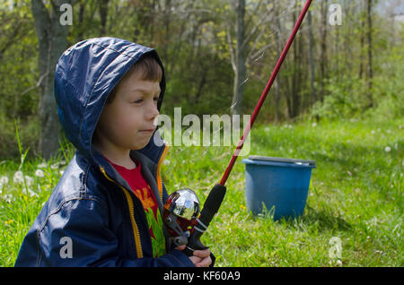 5-6 year old boy fishing by a pond in summer. Stock Photo