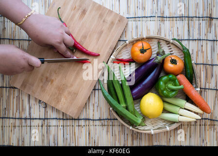 vegetables. chili pepper and knife on cutting board. home concept Stock Photo