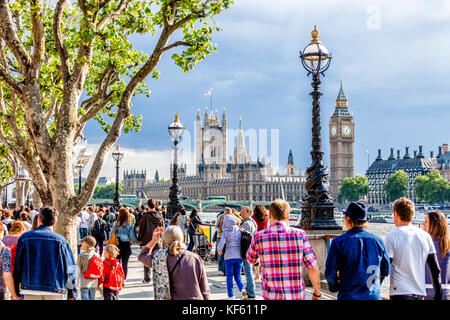 Crowd of people walking on the southern bank of the River Thames, London Stock Photo