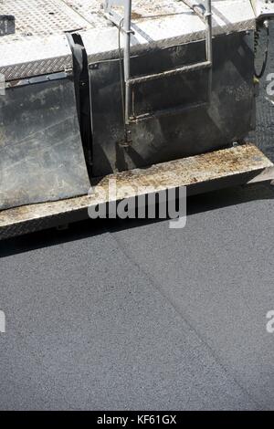 Tracked paver in asphalt pavement works for street repairing. Stock Photo