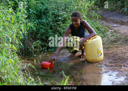 Living in the Kenya Slum Aerias - Woman collecting drinking water from source Stock Photo