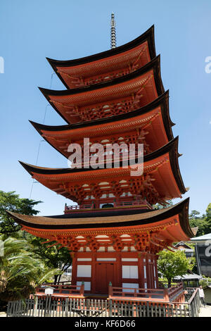 Miyajima - Japan, May 26, 2017: Historic vermillion wooden Five-storied Pagoda, Gojunoto, located in front of the entrance to Itsukushima Shrine Stock Photo