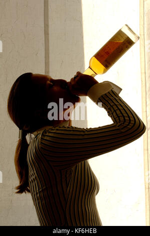 Woman drinks from a liquor bottle     Credit © Luigi Innamorati/Sintesi/Alamy Stock Photo Stock Photo