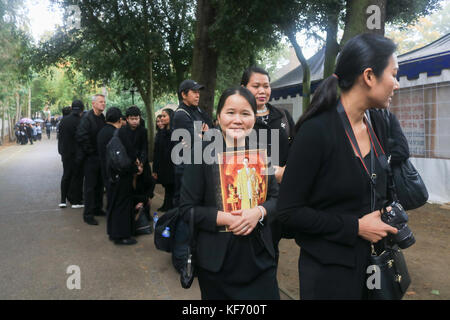 London, UK. 26th Oct, 2017. Hundreds of mourners from the British Thai Community dressed in black paid their respect in the rain at the Buddhapadipa Thai Buddhist temple in Wimbledon to King Bhumibol Adulyadej of Thailand who died a year ago  on 24th October 2016, whose  funeral and cremation is taking place today in the Thai capital Bangkok. Credit: amer ghazzal/Alamy Live News Stock Photo