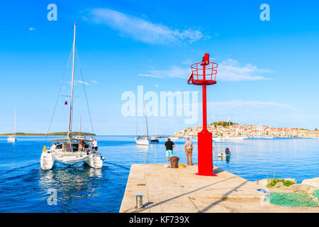 PRIMOSTEN PORT, CROATIA - SEP 5, 2017: Catamaran with tourists sailing out of Primosten port, Dalmatia, Croatia. Stock Photo