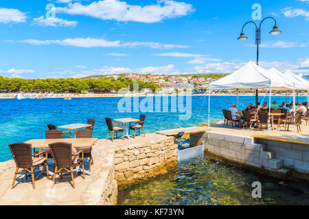 PRIMOSTEN, CROATIA - SEP 5, 2017: tourists sitting in coastal bar in Primosten town, Dalmatia, Croatia. Stock Photo