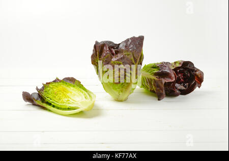 two and half heads of fresh lettuce on white wooden background Stock Photo
