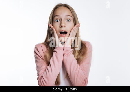 Teenage girl pressing palms to face and screaming Stock Photo