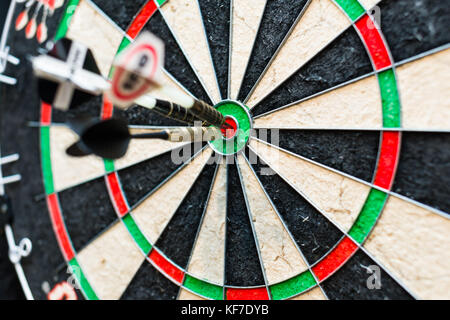 Dart board with three darts in bullseye Stock Photo