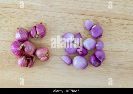 Whole and peeled shallots on a wooden cutting board Stock Photo