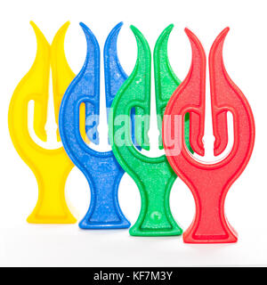 A collection of four colourful clothes pegs shot against a white background. Stock Photo