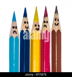 A macro shot of a group of coloured pencils with faces drawn on them. Stock Photo