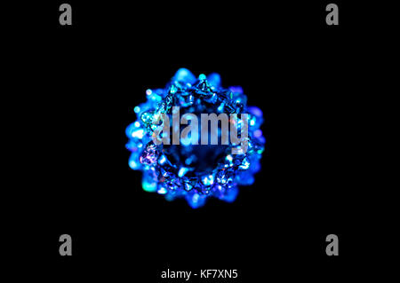 A small lighting blue Christmas tree on the black background. Selective focus, top view. Abstract colorful Christmas background. Stock Photo