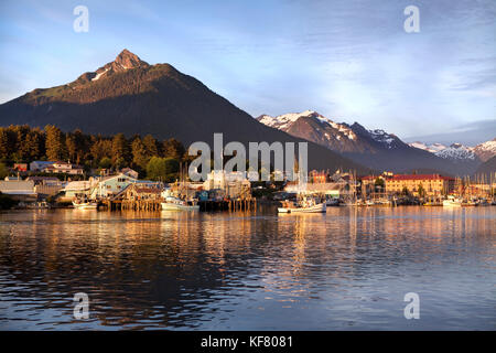 USA, Alaska, Sitka, a peaceful view of homes and fishing boats along the shore in Sitka Harbor at sunset, Crescent Bay Stock Photo