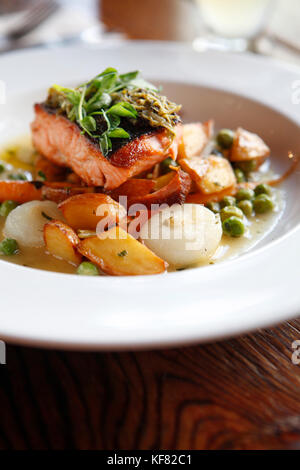 USA, California, Oakland, Chop Bar, Local King Salmon, English Peas, baby carrots, crispy potatoes, cipollini onions, salmon fumet, pea shoot salsa ve Stock Photo