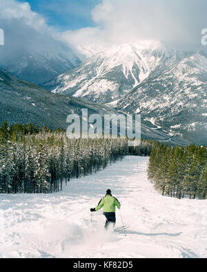 CANADA, BC Rockies, skiing the bumps at Panorama Ski Resort with snow covered mountain in background Stock Photo