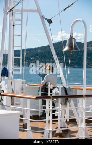 CANADA, Vancouver BC, a couple takes in the scenery off the Holland America cruise ship, the Oosterdam, as it leaves Vancouver BC and passes under the Stock Photo