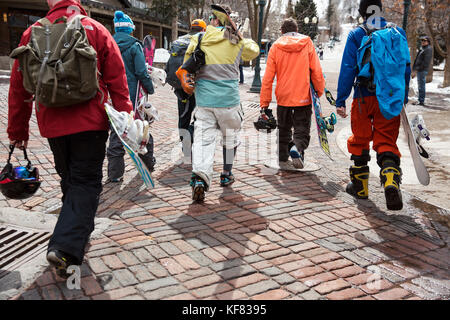 USA, Colorado, Aspen, skiers and snowboarders walk through the square towards the base of Aspen Mountain, Aspen Ski Resort Stock Photo