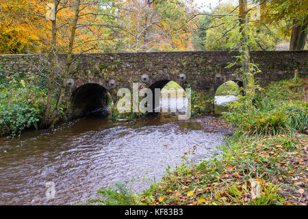 The beautiful Minnowburn stone bridge near Shaw's Bridge on the outskirts of South Belfast in Northern Ireland. Taken against a backdrop of glorious a Stock Photo