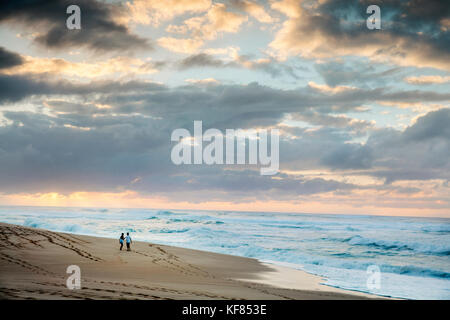 HAWAII, Oahu, North Shore, a couple walking at sunset on Sunset Beach Stock Photo