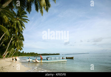 INDONESIA, Mentawai Islands, Kandui Surf Resort, surfers loading a boat to go surfing Stock Photo