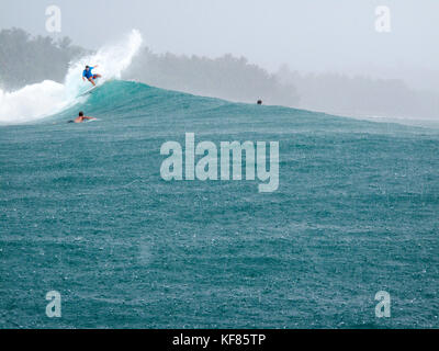 INDONESIA, Mentawai Islands, Kandui Resort,  surfing a wave at Beng Beng in the pouring rain Stock Photo