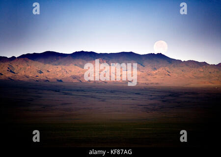 MONGOLIA, Gobi Desert, barren landscape under the setting full moon in the morning Stock Photo