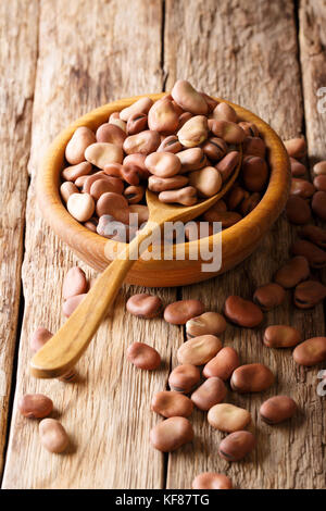 Natural broad beans close-up in a wooden bowl on a table. vertical Stock Photo