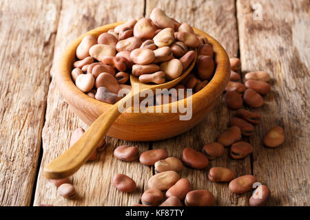 Dried organic healthy broad beans close-up in a wooden bowl on a table. horizontal Stock Photo