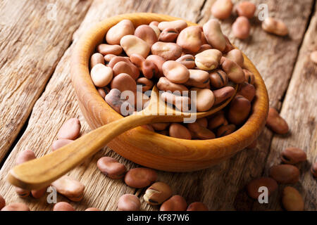 large dried broad beans close-up in a wooden bowl on the table. horizontal Stock Photo